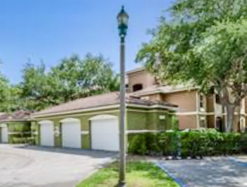 5060 Fairways Circle, Unit F207 Vero Beach, FL 32967 - Photo 6 of 14 a view of a white house next to a yard with potted plants