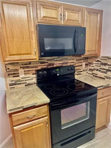a kitchen with wooden cabinets and a stove top oven