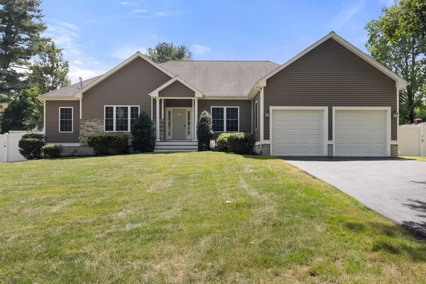 a front view of house with yard and trees around