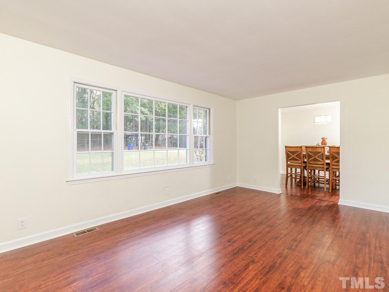 4313 Hopson Drive Raleigh, NC 27604 - Photo 5 of 30 a view of an empty room with wooden floor and a window