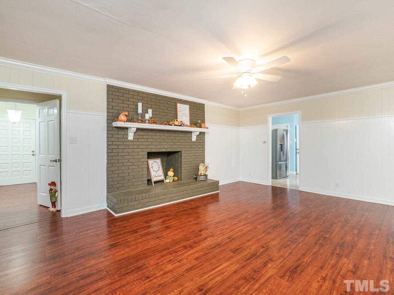 4313 Hopson Drive Raleigh, NC 27604 - Photo 7 of 30 a view of an empty room with wooden floor fireplace and a window