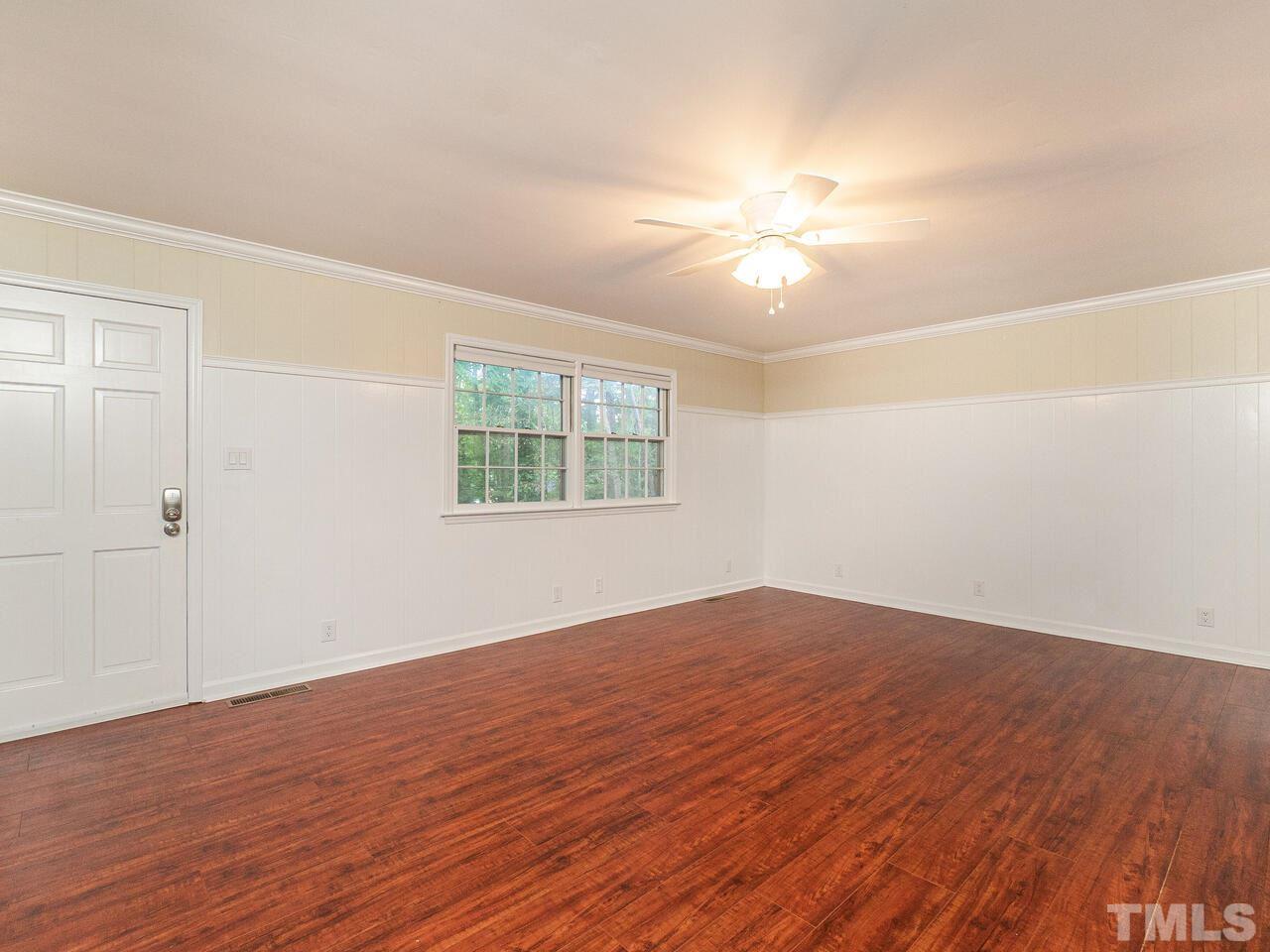 4313 Hopson Drive Raleigh, NC 27604 - Photo 9 of 30 an empty room with wooden floor fan and windows