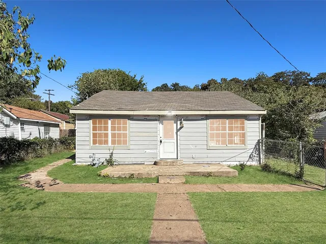 a front view of a house with a yard and potted plants