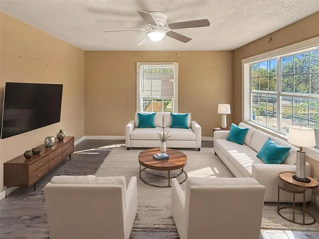 a living room with furniture a flat screen tv and a large window
