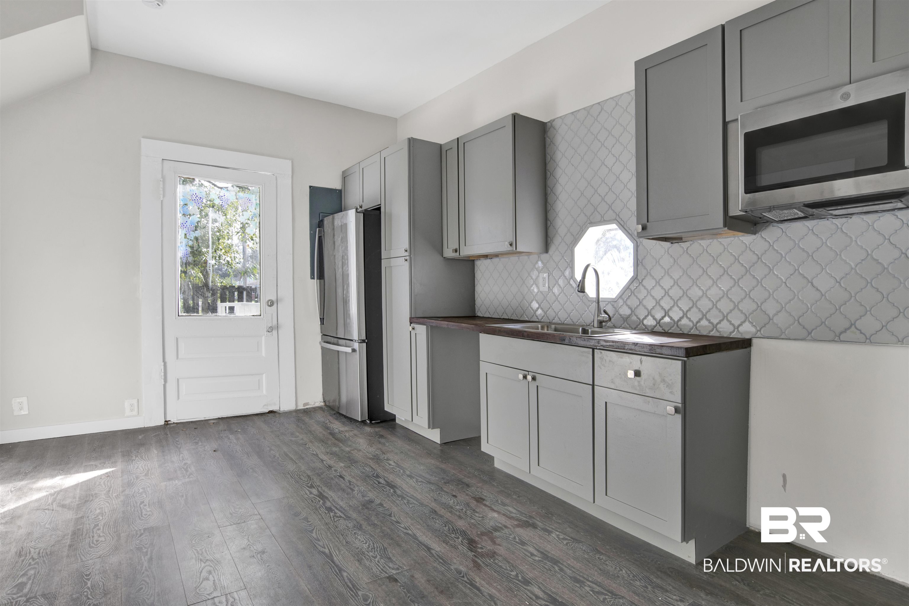 1063 Selma Street Mobile, AL 36604 - Photo 12 of 32 Kitchen with gray cabinets, stainless steel appliances, dark wood-type flooring, and tasteful backsplash