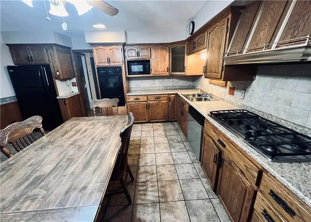 a kitchen with stainless steel appliances granite countertop a stove a sink dishwasher and a refrigerator