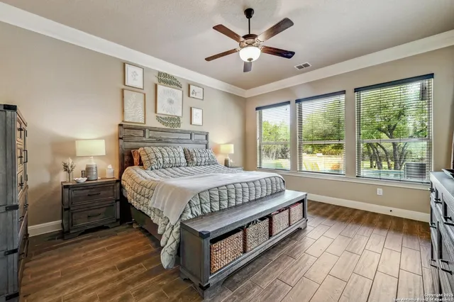 a spacious bedroom with a bed and a large window with wooden floor