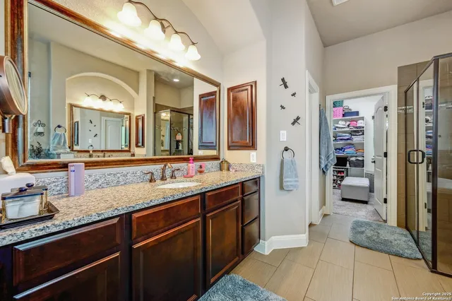 a spacious bathroom with a granite countertop sink mirror and shower