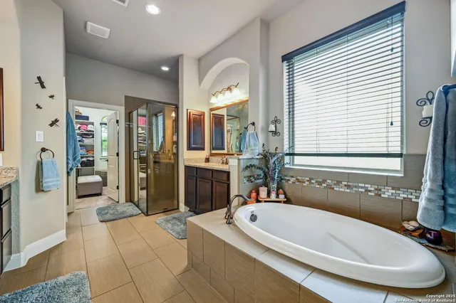 a bathroom with a tub a sink and a mirror