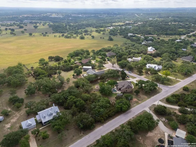 an aerial view of residential houses with outdoor space and ocean view