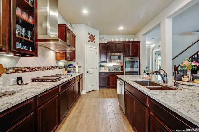 a kitchen with stainless steel appliances granite countertop a sink stove and refrigerator