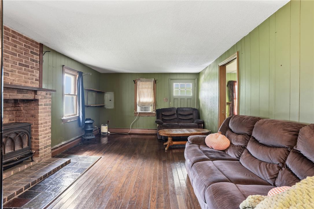 3573 Lower Saucon Road Hellertown, PA 18055 - Photo 6 of 56 Rich hardwood flooring complements a robust brick fireplace in this inviting living space.