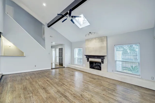 a kitchen with stainless steel appliances kitchen island granite countertop a sink dishwasher stove top oven and refrigerator with wooden floor