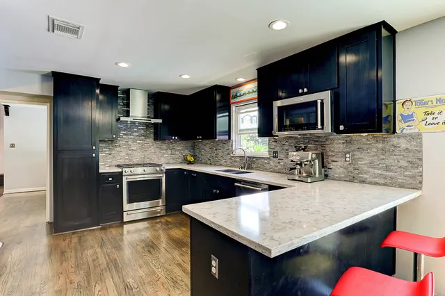 a kitchen with stainless steel appliances granite countertop a refrigerator and a sink