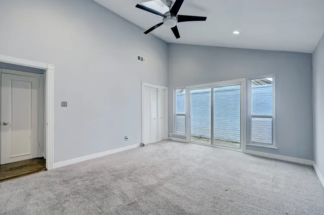 a view of a room with wooden floor and ceiling fan