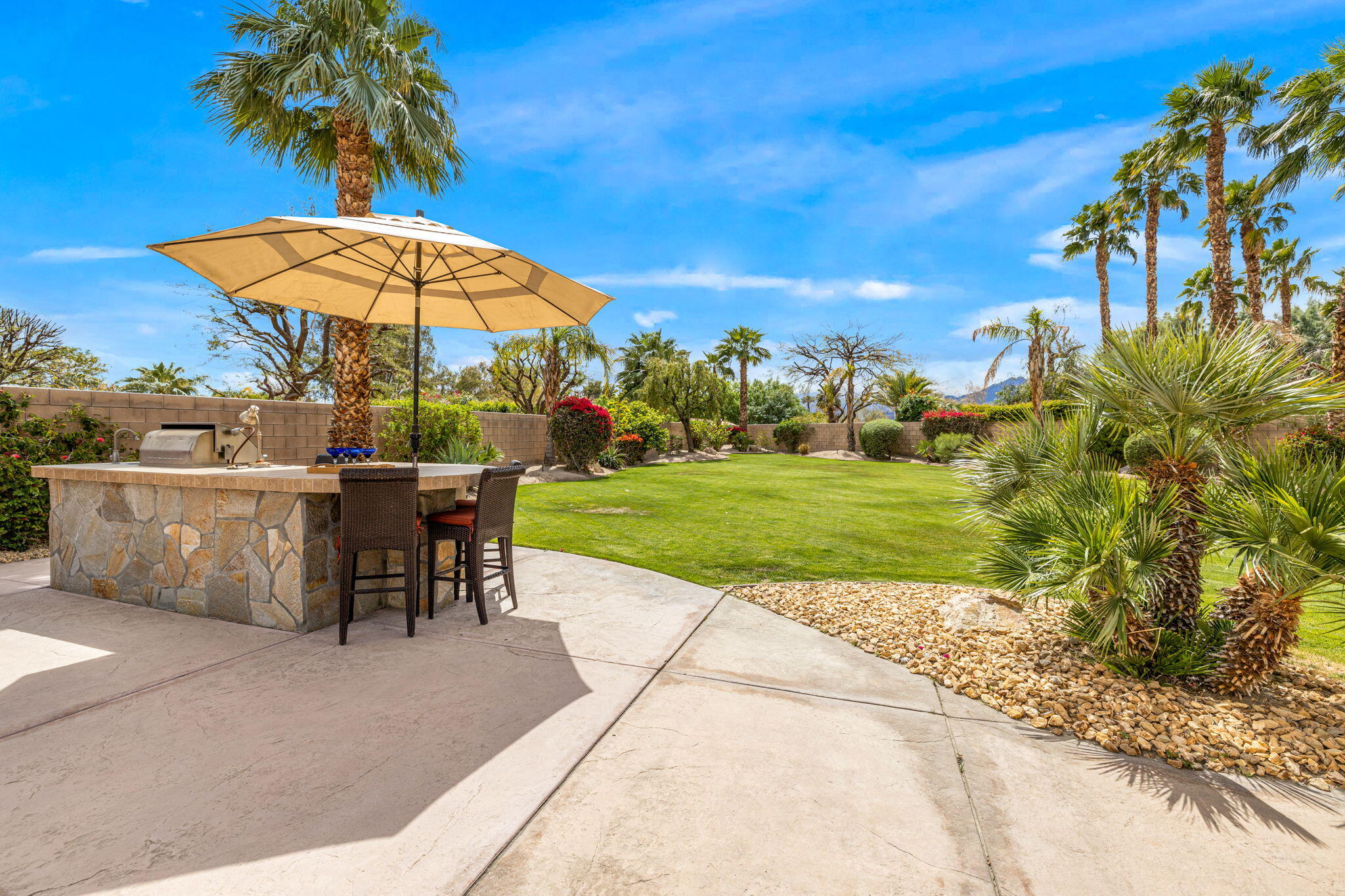 49722 Jordan Street Indio, CA 92201 - Photo 34 of 38 a view of a swimming pool with a table and chairs under an umbrella