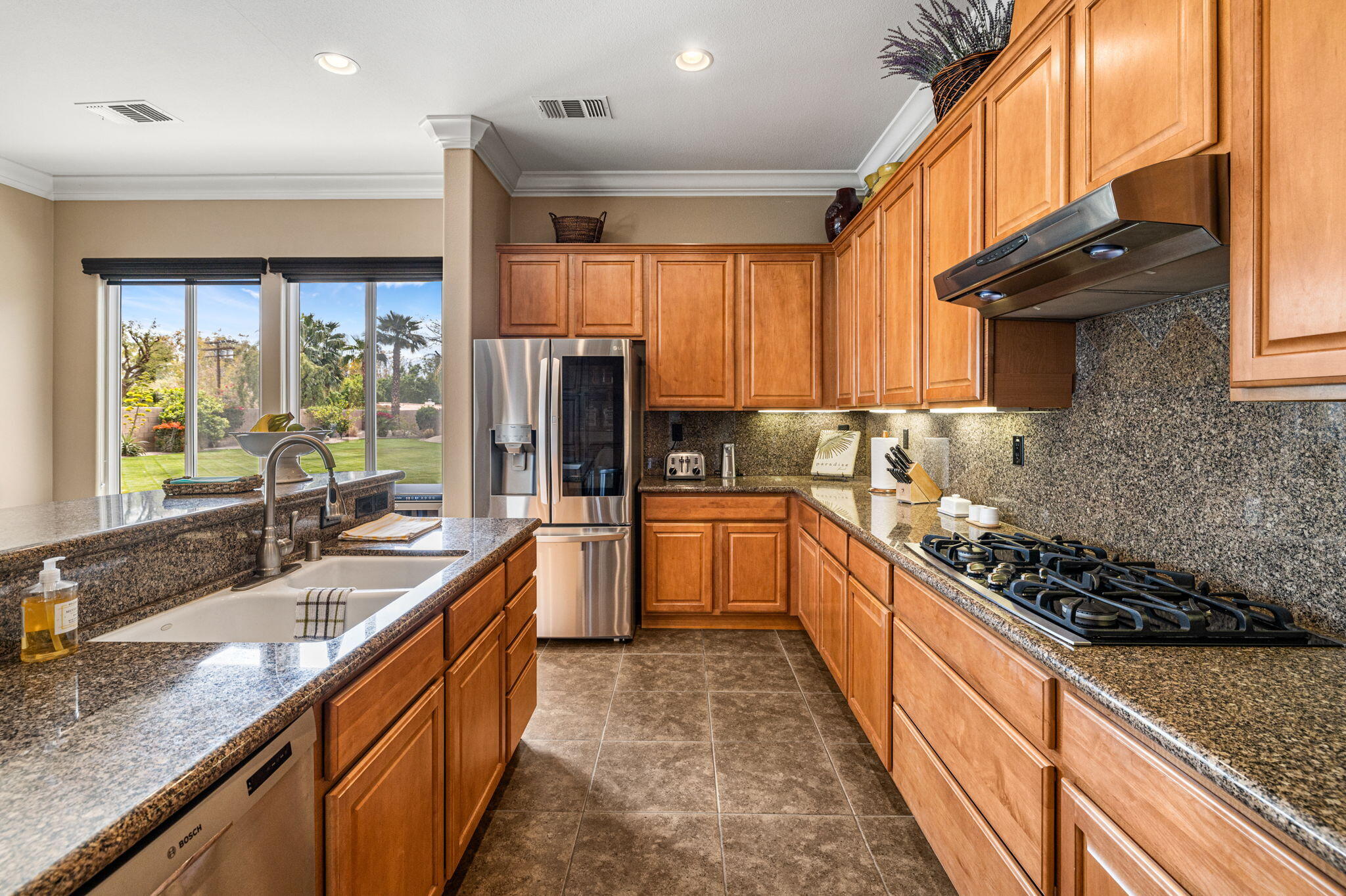 49722 Jordan Street Indio, CA 92201 - Photo 10 of 38 a kitchen with stainless steel appliances kitchen island granite countertop a sink stove and refrigerator