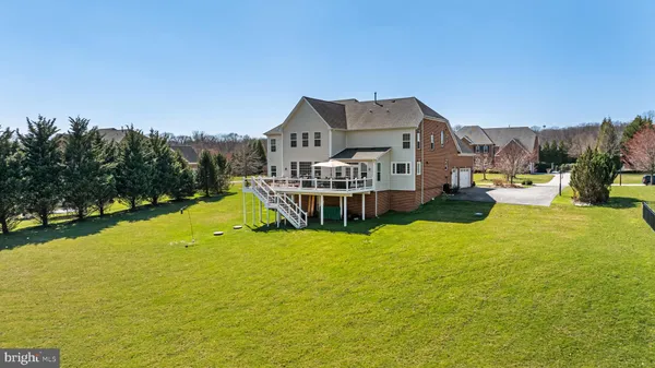 a view of a house with a big yard and large trees