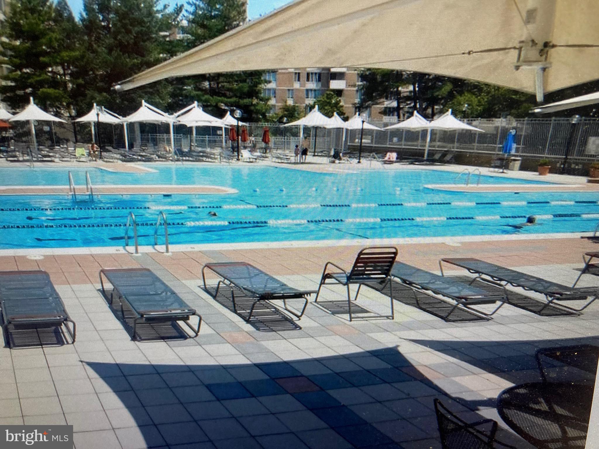 2939 Van Ness Street Northwest, Unit 731 Washington, DC 20008 - Photo 14 of 14 a view of a white house with a yard swimming pool and sitting area