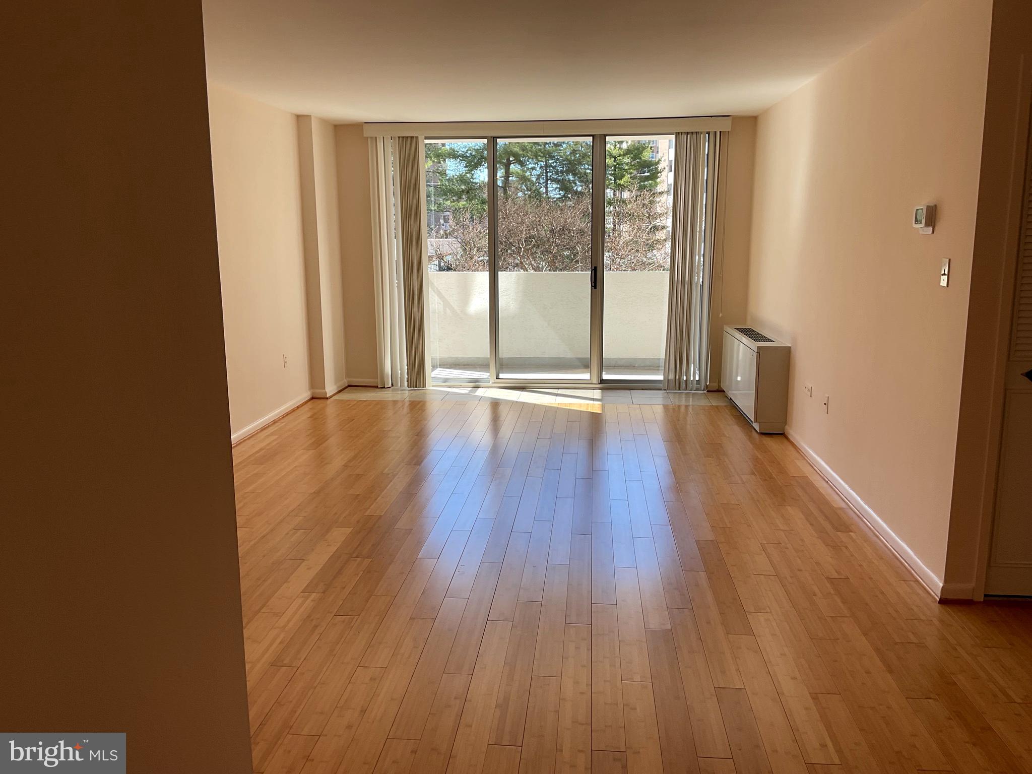 2939 Van Ness Street Northwest, Unit 731 Washington, DC 20008 - Photo 8 of 14 a view of an empty room with wooden floor and a window