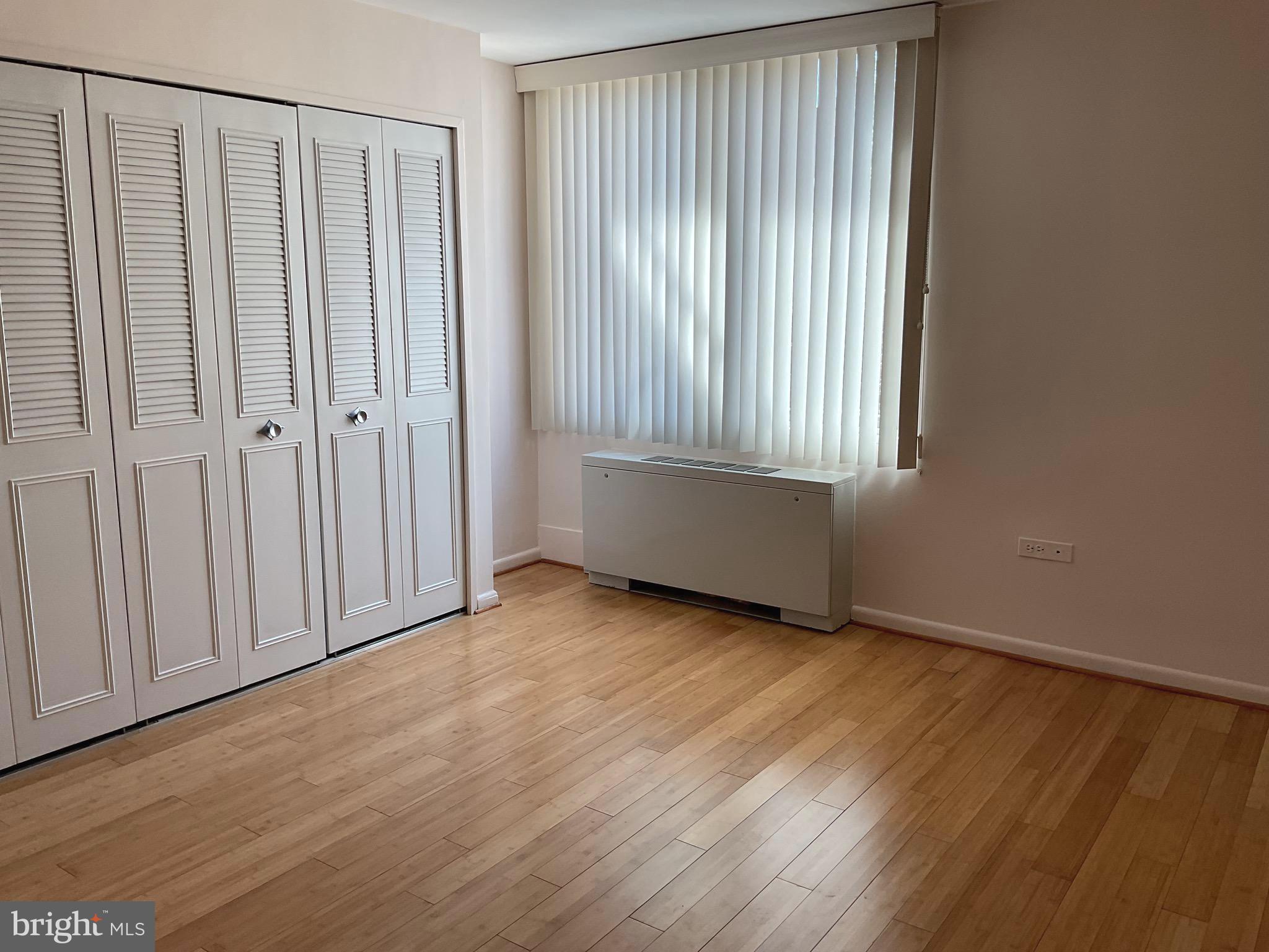 2939 Van Ness Street Northwest, Unit 731 Washington, DC 20008 - Photo 9 of 14 a view of an empty room with wooden floor and a window