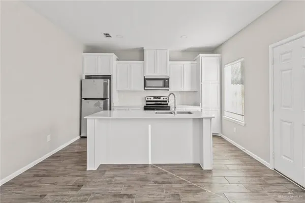 a kitchen with stainless steel appliances granite countertop a stove a sink and a refrigerator