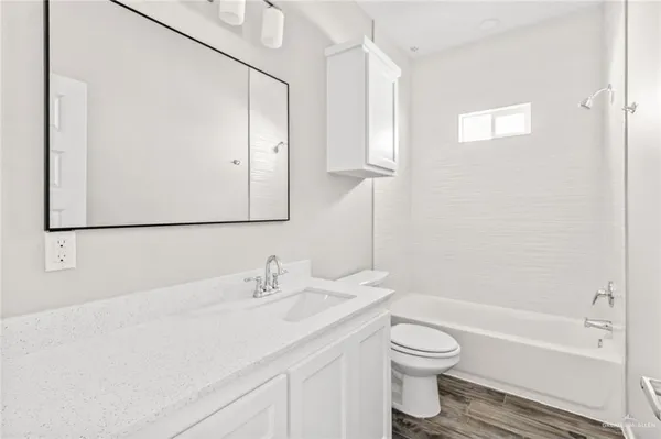 a bathroom with a toilet a sink a mirror and a bathtub