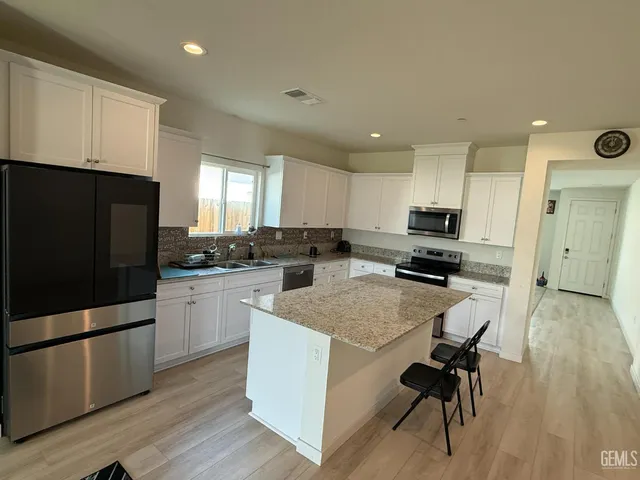 a kitchen with refrigerator cabinets and wooden floor