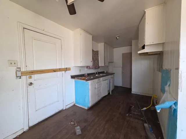 a kitchen with granite countertop white cabinets and white appliances