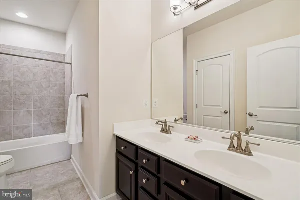 a bathroom with a double vanity sink toilet and shower