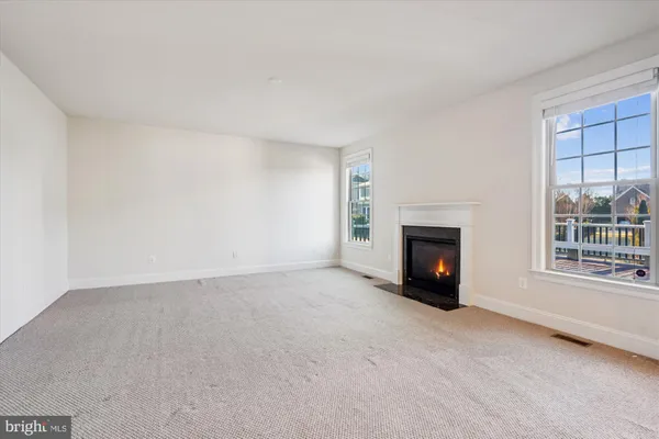 a view of an empty room with a fireplace and a window
