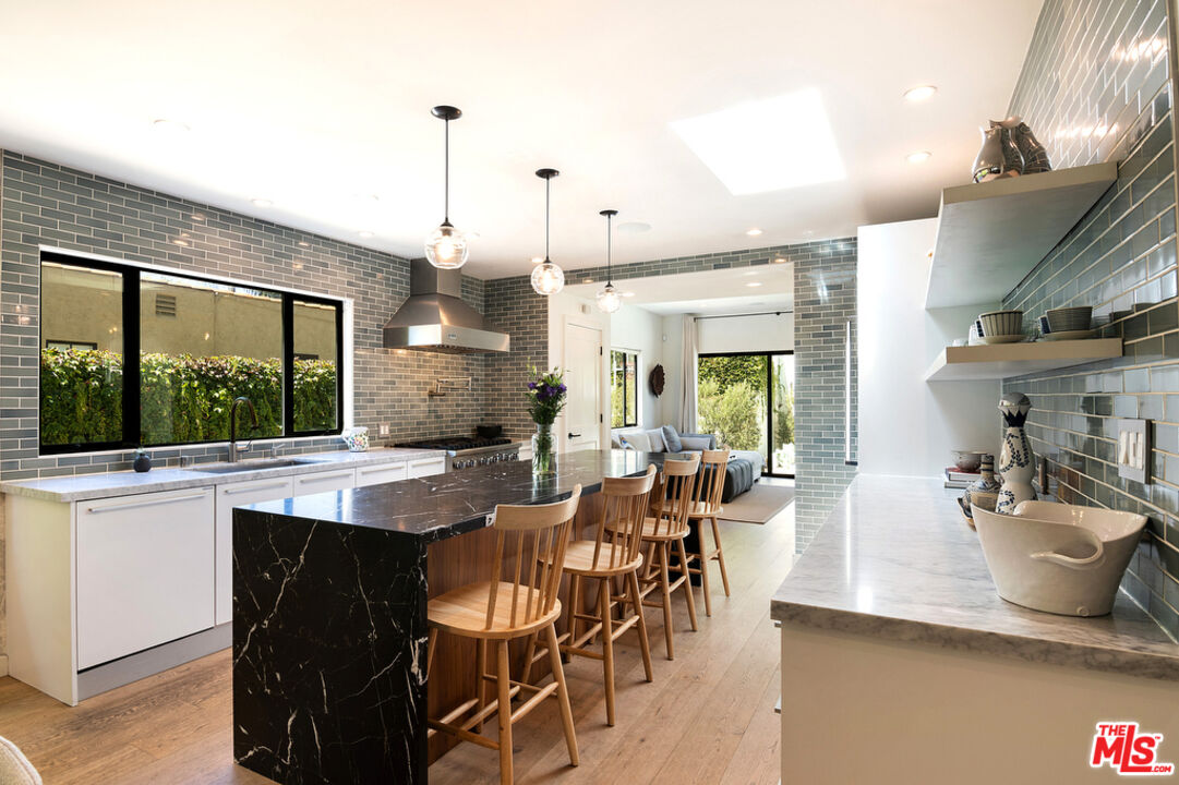 743 North June Street Los Angeles, CA 90038 - Photo 16 of 38 a dining hall with stainless steel appliances kitchen island granite countertop a table chairs and a view of living room