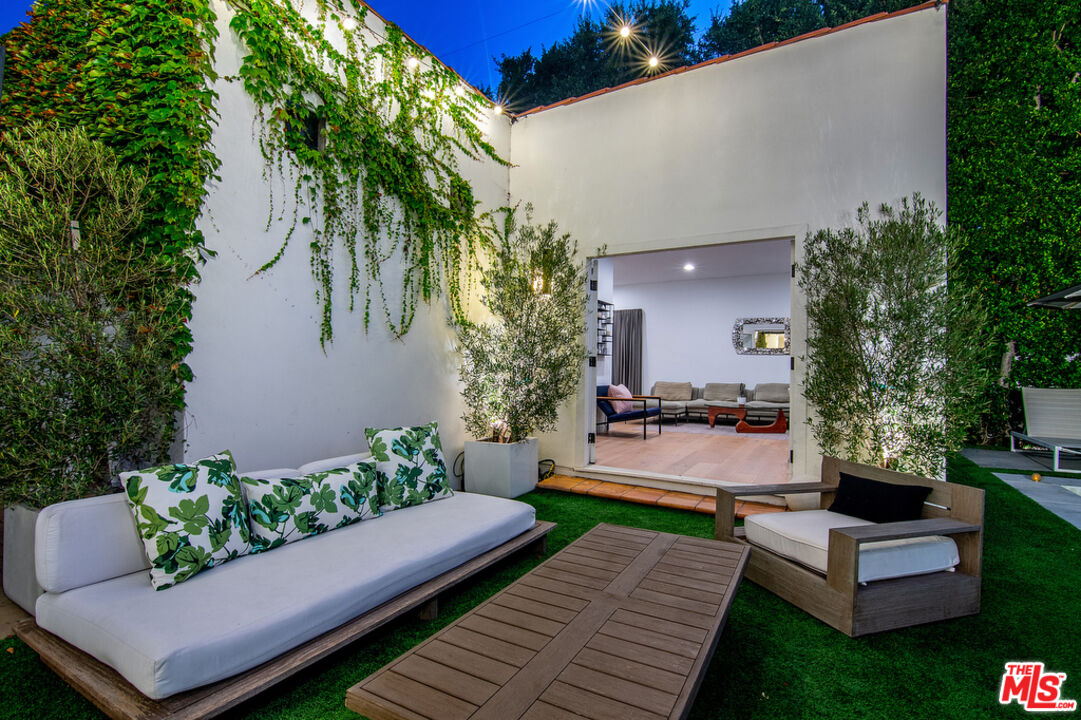 743 North June Street Los Angeles, CA 90038 - Photo 34 of 38 a view of a patio with couches table and chairs potted plants and a large tree