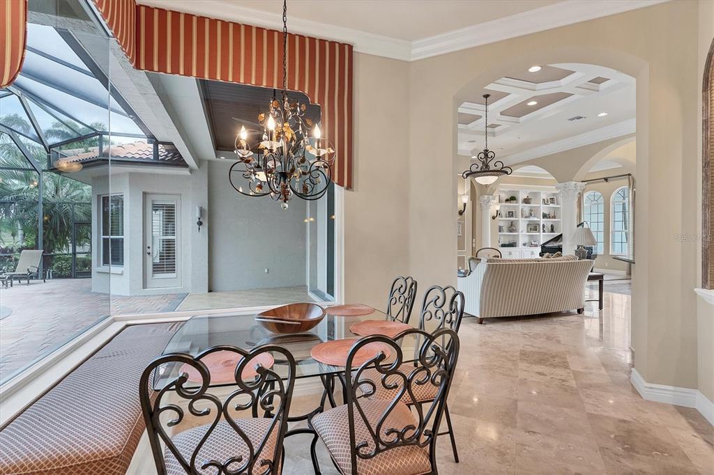 7007 Portmarnock Place Lakewood Ranch, FL 34202 - Photo 19 of 92 a view of a dining room with furniture and a chandelier