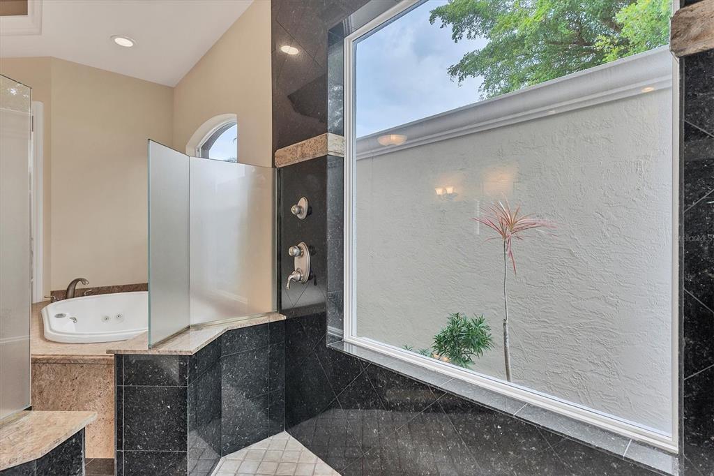 7007 Portmarnock Place Lakewood Ranch, FL 34202 - Photo 40 of 92 a bathroom with a granite countertop sink a toilet and shower