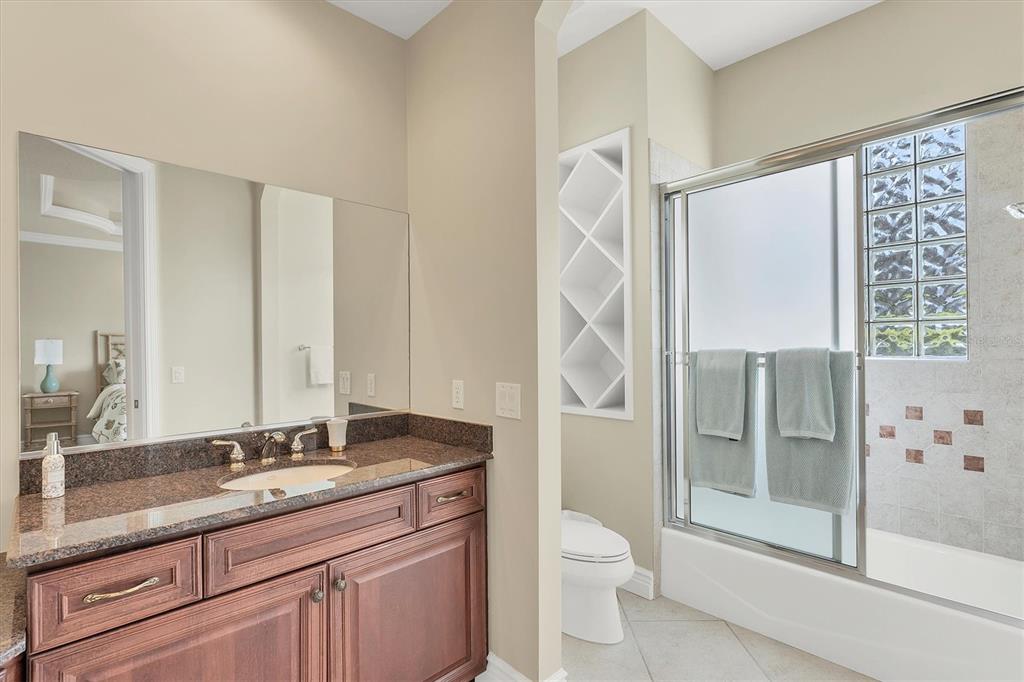 7007 Portmarnock Place Lakewood Ranch, FL 34202 - Photo 49 of 92 a bathroom with a granite countertop sink toilet and shower