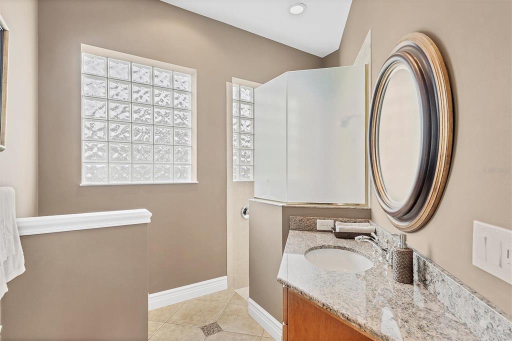 7007 Portmarnock Place Lakewood Ranch, FL 34202 - Photo 52 of 92 a bathroom with a granite countertop sink and a mirror