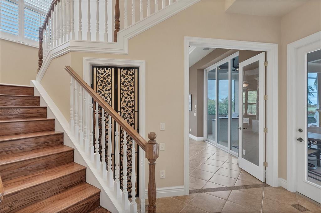 7007 Portmarnock Place Lakewood Ranch, FL 34202 - Photo 54 of 92 a view of staircase with lots of frames on wall and a potted plant