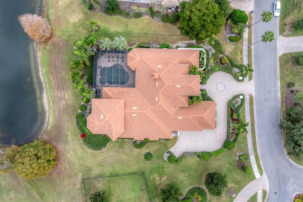7007 Portmarnock Place Lakewood Ranch, FL 34202 - Photo 74 of 92 an aerial view of a house with a yard and a large pool