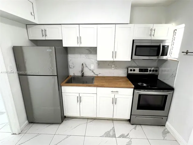 a kitchen with stainless steel appliances granite countertop a refrigerator and a stove