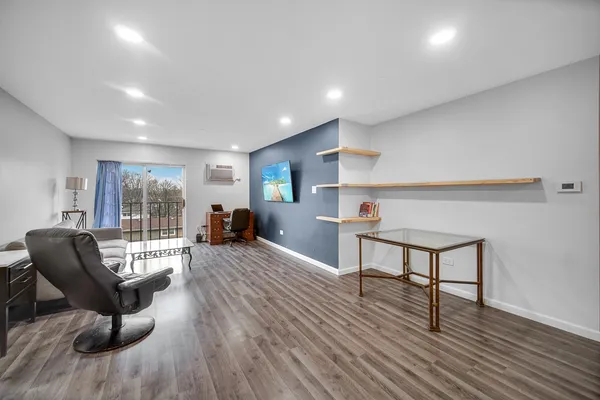 a living room with furniture a wooden floor and a window