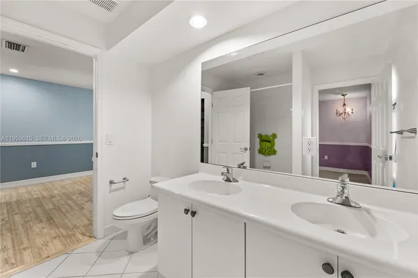 a bathroom with a sink double vanity and toilet