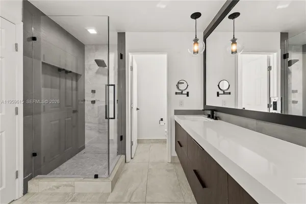 a spacious bathroom with a double vanity sink mirror and shower