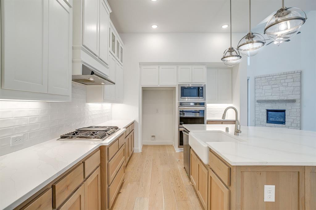 14328 Capridge Road Fort Worth, TX 76008 - Photo 9 of 39 a kitchen with kitchen island a counter space a sink appliances and cabinets