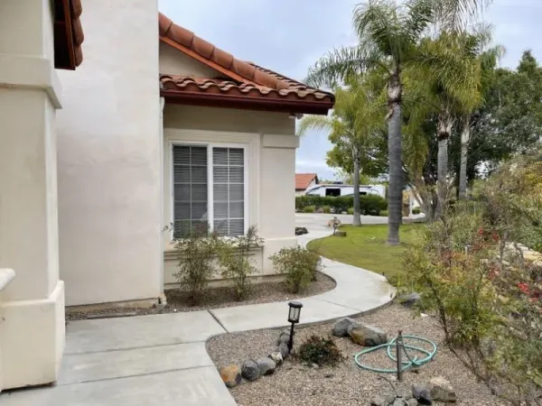 a view of a chair and table in backyard of the house