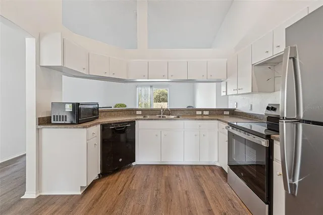 a kitchen with a refrigerator stove and white cabinets