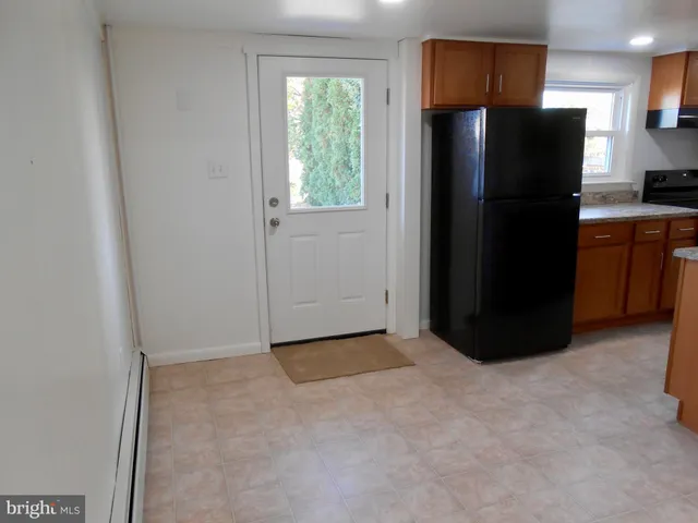 a view of a refrigerator in kitchen and a window
