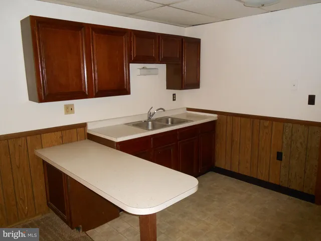 a kitchen with a sink cabinets and wooden floor