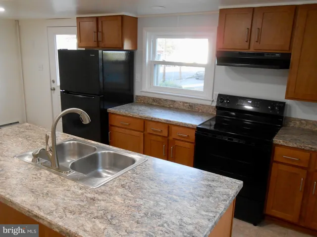 a kitchen with granite countertop a refrigerator and a sink