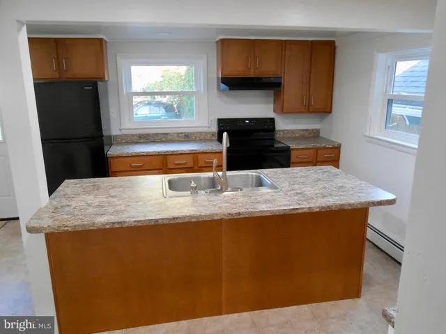 a kitchen with granite countertop a sink a counter top space and cabinets